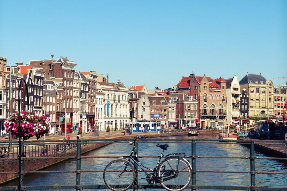 Cyclist by the canals in a historic Dutch city, tourist location.